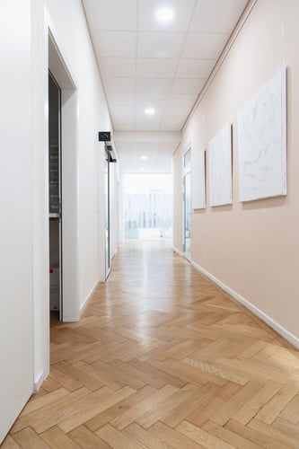 Couloir moderne d’Ardentis Cliniques Dentaires et d'Orthodontie La Tour-de-Peilz reliant les espaces de soins dentaires et d’orthodontie dans un environnement lumineux, contemporain et pensé pour le confort des patients.