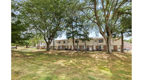 A grassy area with trees and apartment buildings in the background at Indian Valley Apartments in Kent, OH, 44240
