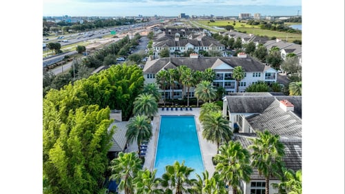Outdoor pool with trees in an apartment complex.