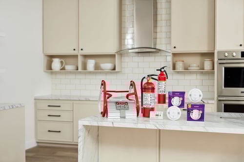A group of Kidde Products sit on a kitchen counter.