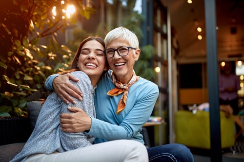 Mother and adult daughter hugging