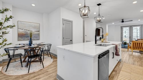An open kitchen and dining area with a table and chairs at Meridian at CityPlace, Woodbury, MN