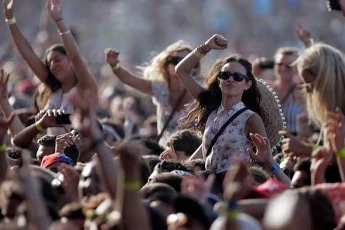 people dancing and fist pumping at a festival