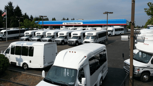 exterior of sales lot with several buses for sale
