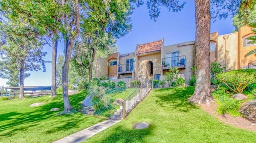 Exterior of apartments with paved walkways and a tree-lined view at Woodlake, Escondido