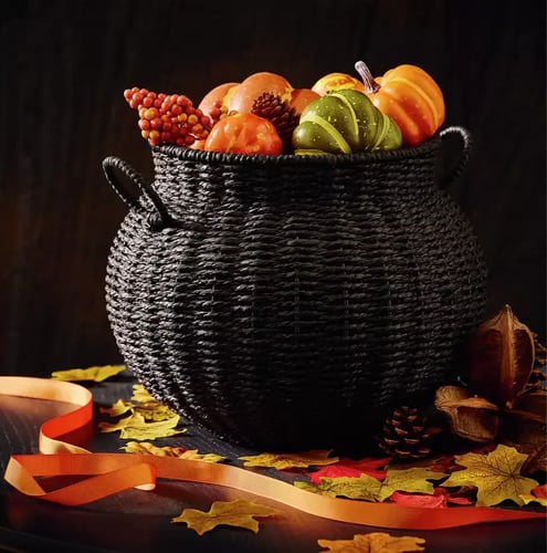 Black basket weave cauldron with assorted small pumpkins inside