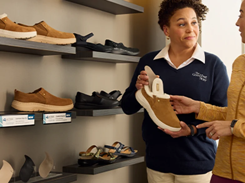 good feet store employee holding an architek slip on talking to customer