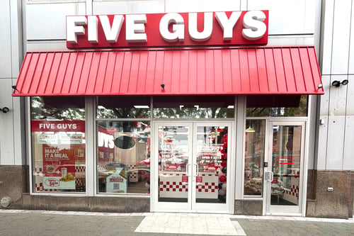 Exterior photograph of the Five Guys restaurant at 600 East Pratt Street in Baltimore, Maryland.