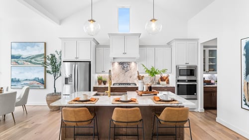 Chef-inspired kitchens with expansive islands, two-tone cabinetry, pendant lighting, stainless steel appliances and casual dining spaces