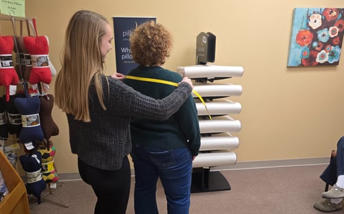 Allison, chiropractic assistant at Healthy Lifestyles Chiropractic measuring a patient for a therapeutic pillow