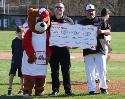 Matt and Mr. Neighbear holding a donation check