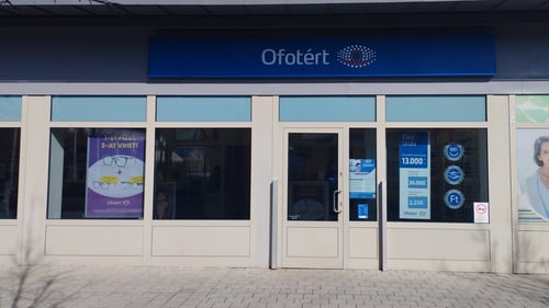 Az Ofotért optika üzlet homlokzata Budapesten, üvegportállal és kirakati plakátokkal.