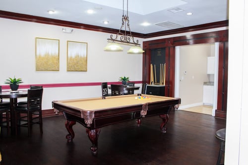 Wooden billiards table, with dark wood flooring and seating area at Montfort Place Apartments, Dallas 75254