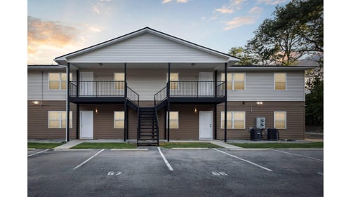 A two-story apartment building with a parking lot in front at Seasons Apartments in Statesboro, GA, 30458