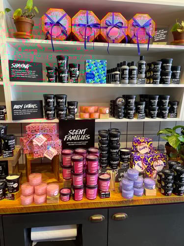 Interior view of shop. Various packaged and unpackaged  products displayed on countertop and wooden shelves above.