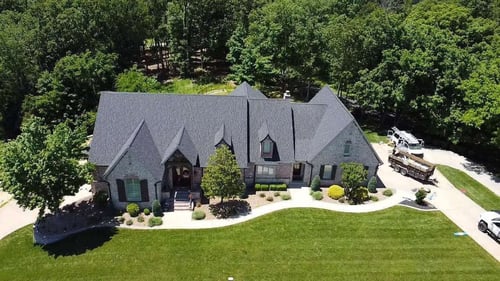 Grey roofing with green trees in background and green lawn