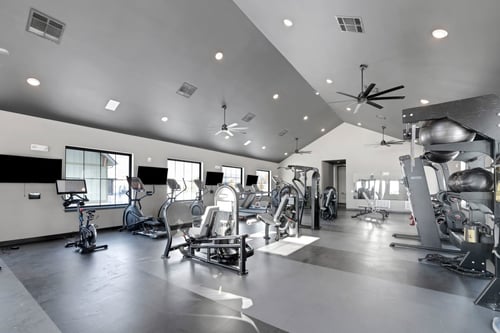 A fitness center with treadmill and other equipment at The Depot, Raymore, MO