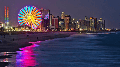 view of Myrtle Beach at night with a ferris wheel in the background