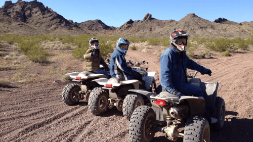 three people riding ATV's