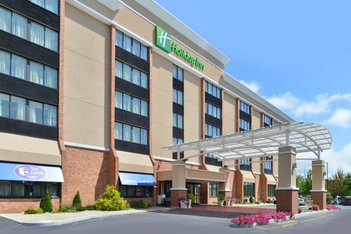 New London hotel exterior with covered entrance and parking area.