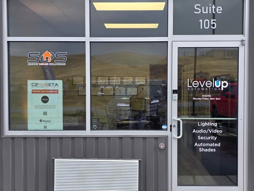 Exterior view of Level Up Automation storefront at Suite 105, showcasing the front entrance, window signage, and branding.