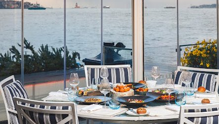 A table with a beautiful selection of foods overlooking a river.