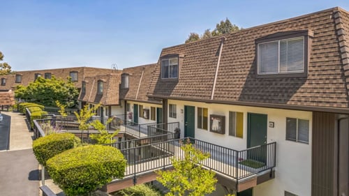 A row of houses with balconies and greenery at Posada East