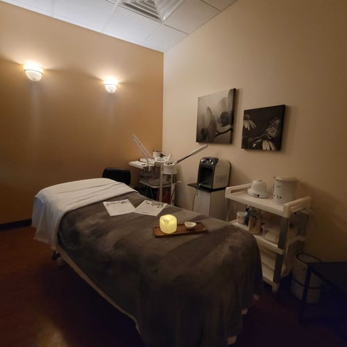 Immaculately staged facial treatment room featuring an advanced DiamondGlow® machine, a perfectly made esthetic bed, warm ambient lighting, and professional skincare backbar lines at Hand & Stone Spa in Lakeview, Chicago IL.