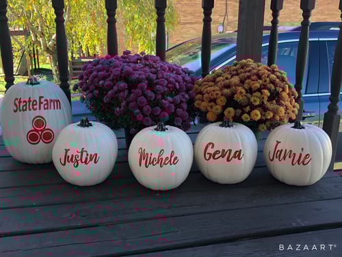 White pumpkins with red lettering with State Farm logo and team member names