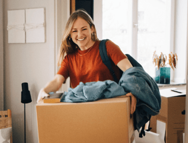 Young women carrying box back into home she grew up in