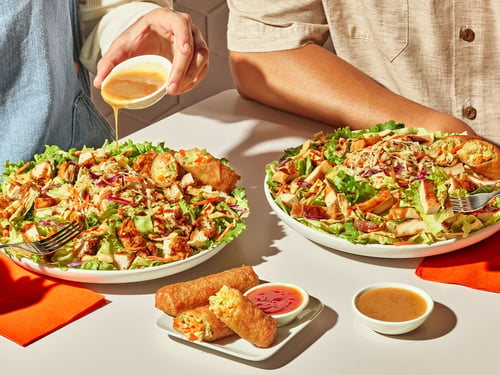 Two Asian Zensation Zalads with crispy chicken, egg rolls, and dressing at Zaxby’s