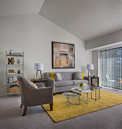 spacious living room of Plymouth Woods Apartments with a gray and yellow theme