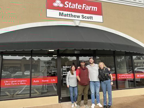Agent Matthew and three team members standing and smiling together outside of agency