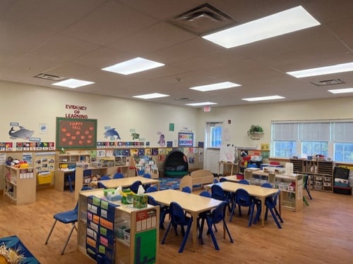 Vibrant Pre-K room with learning centers, craft tables, and interactive play areas supporting early childhood development.