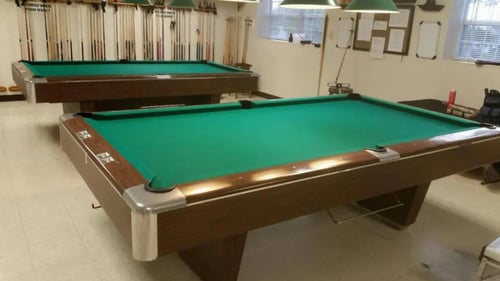 two pool table with green felt