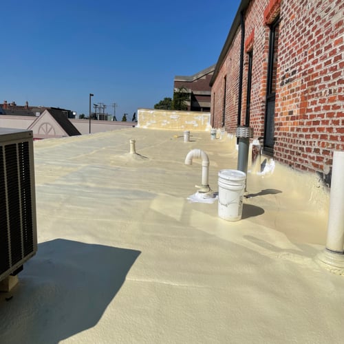 White roof with an air conditioner unit installed, showcasing a modern building design.
