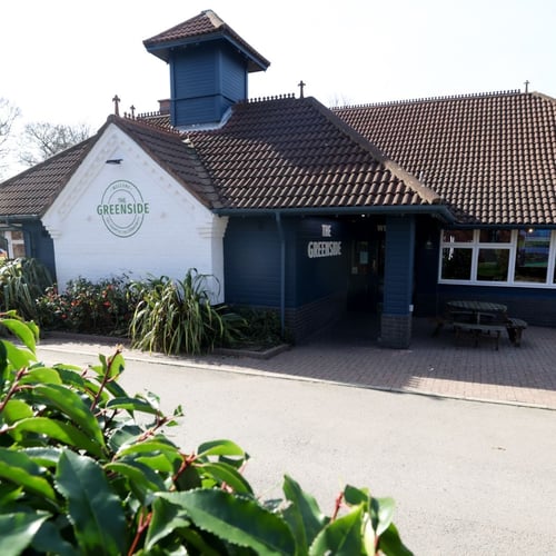 Exterior of The Greenside pub with entrance and signage