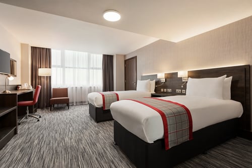Modern twin bedroom with two single beds, TV, desk and tea and coffee making facilities